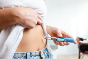 Person administering insulin injection using a pen